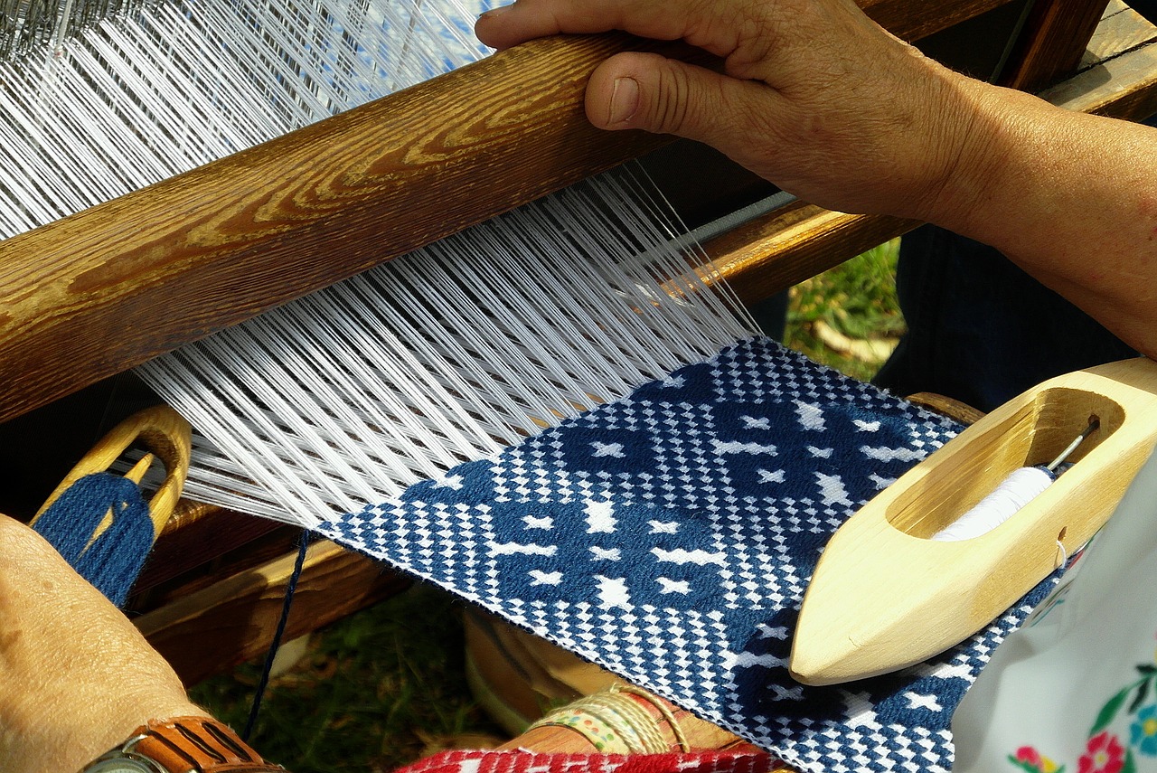 hands of a person weaving a blue and white pattern