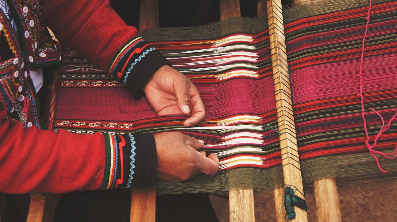 hands of person weaving with a weaving frame